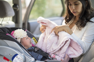 Weinendes Baby im Autositz und ratlose Mutter